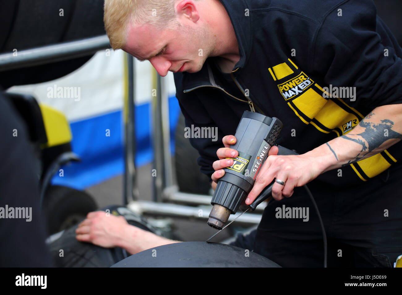 A mechanic prepares tyres in the paddock at Thruxton Race Course