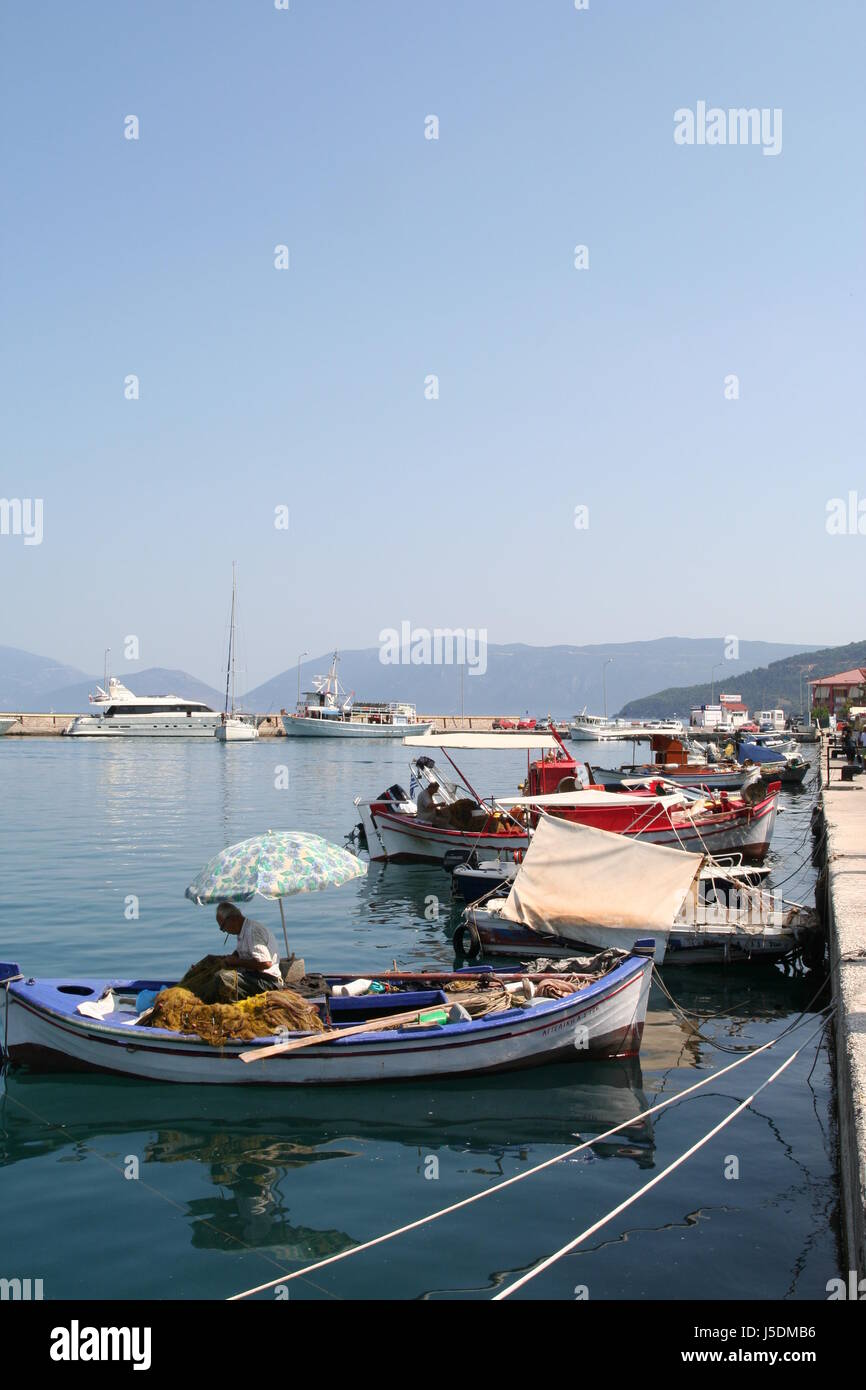 Fishermen in small boats mend their nets in Argostolli, Kefalonia