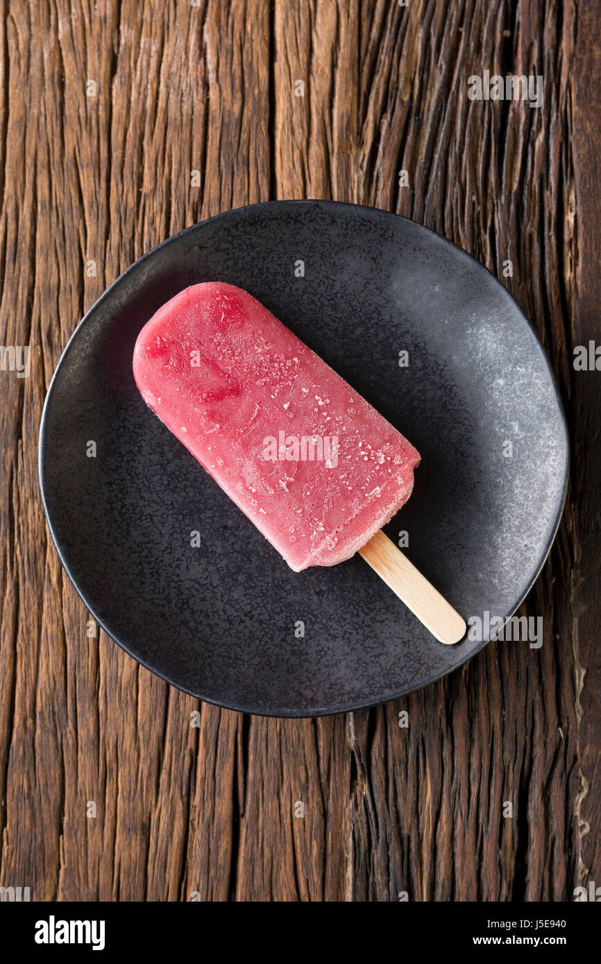 Homemade Raspberry and vanilla ice pop on a rustic wood background. Berry icecream popsicle. Summer food. Stock Photo