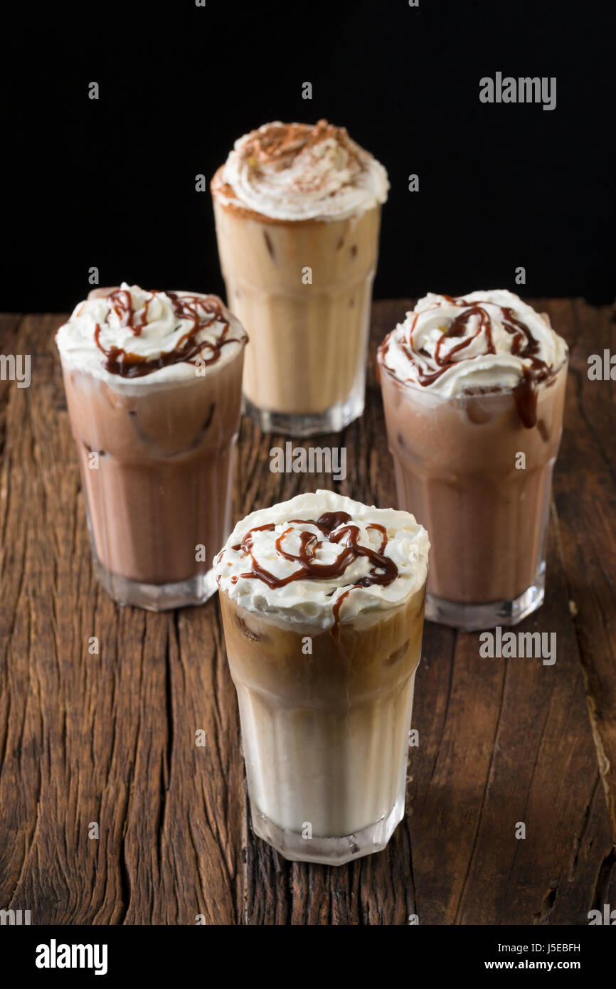 Four glasses of Iced coffee drinks on a rustic wooden table. Stock Photo