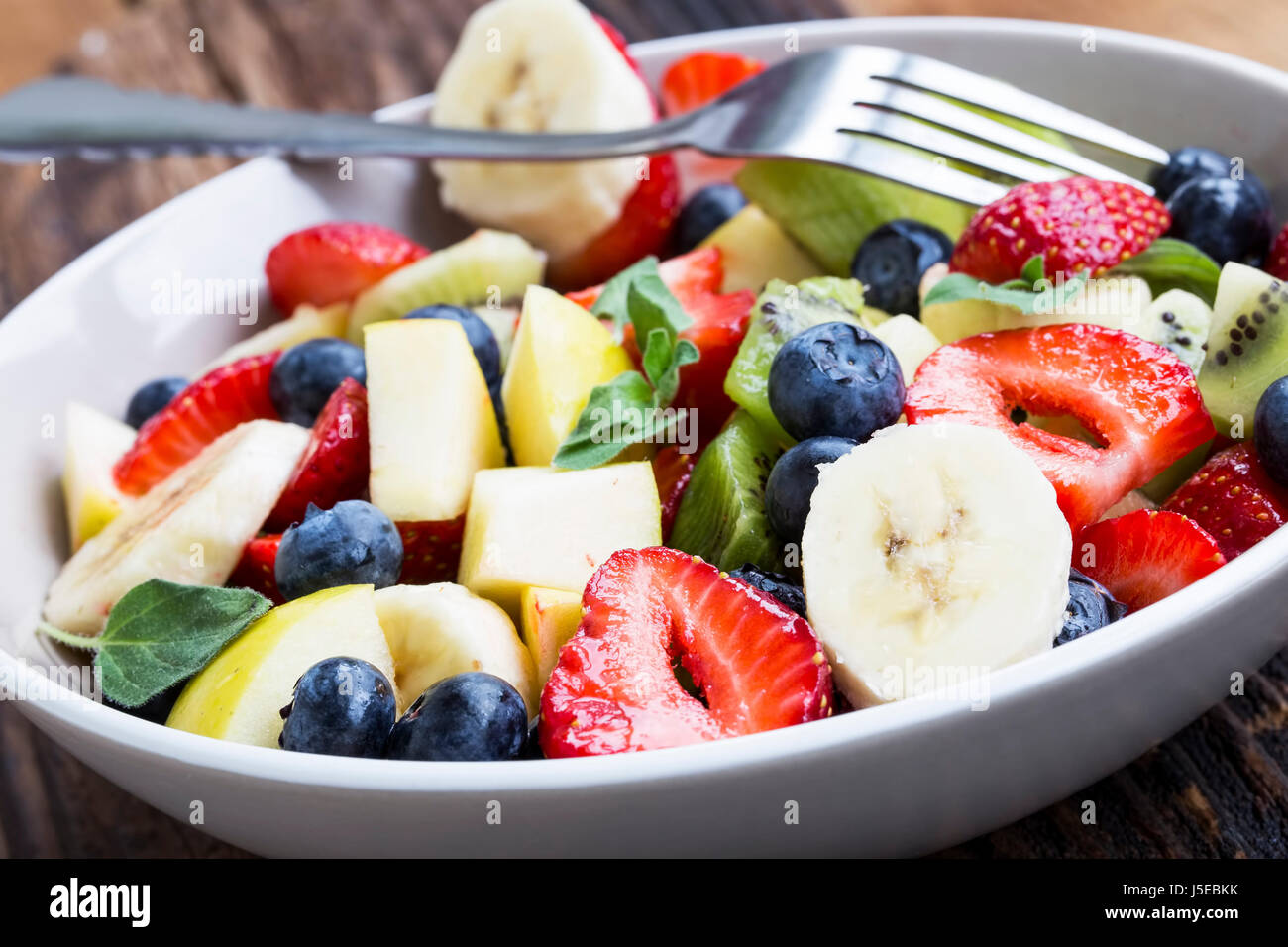 Bowl of fruits salad with strawberries, blueberries, apples, kiwi ...