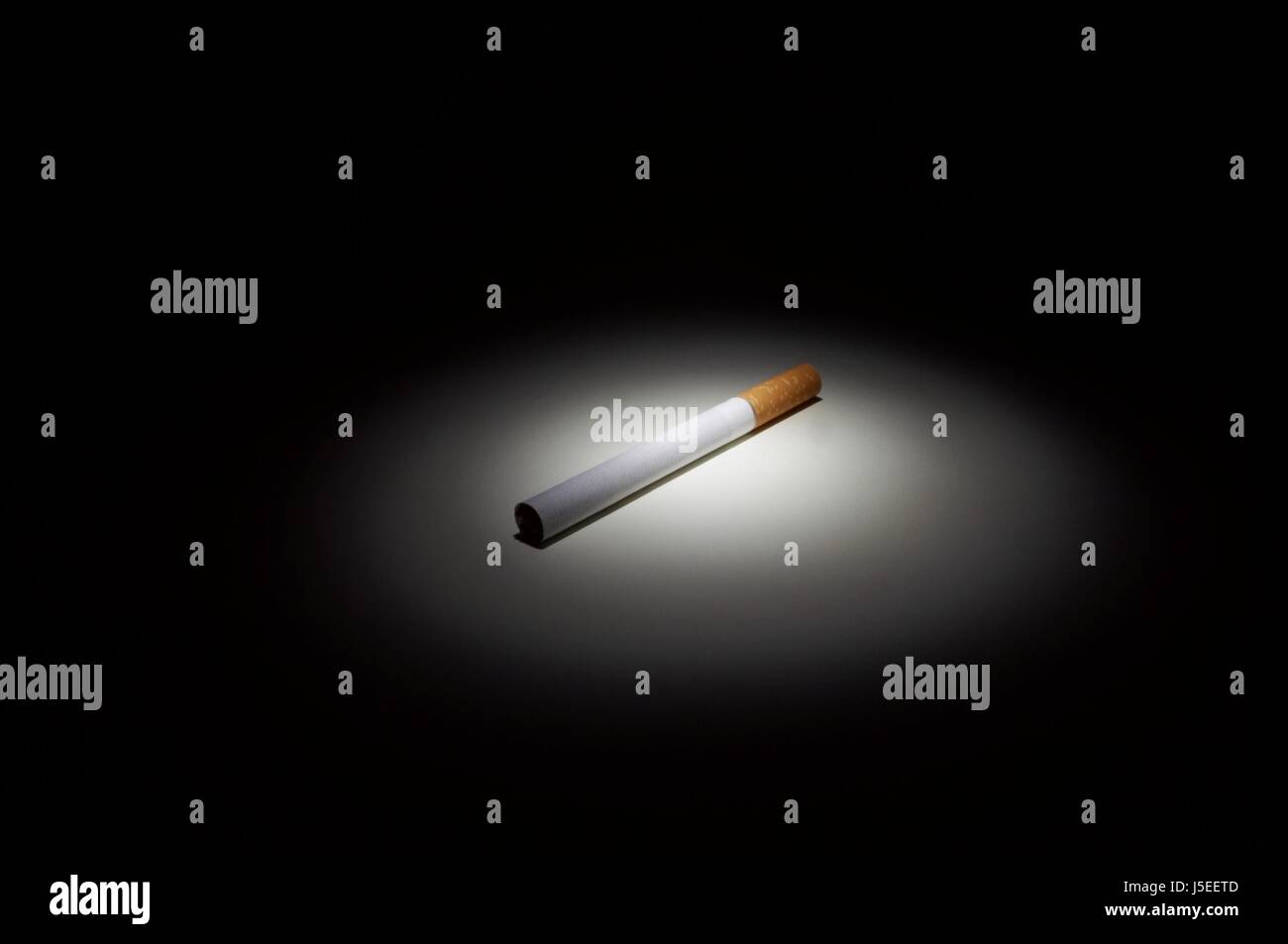 cigarette in spotlight Stock Photo