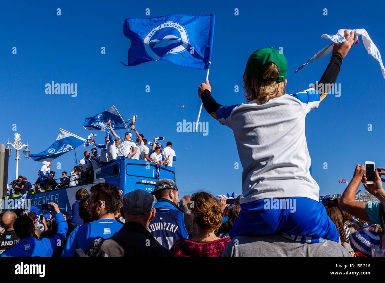 A Cheering Young Brighton and Hove Albion Football Fan Watches As The Team Bus Passes During The Club's Promotion Parade, Brighton, Sussex, UK Stock Photo