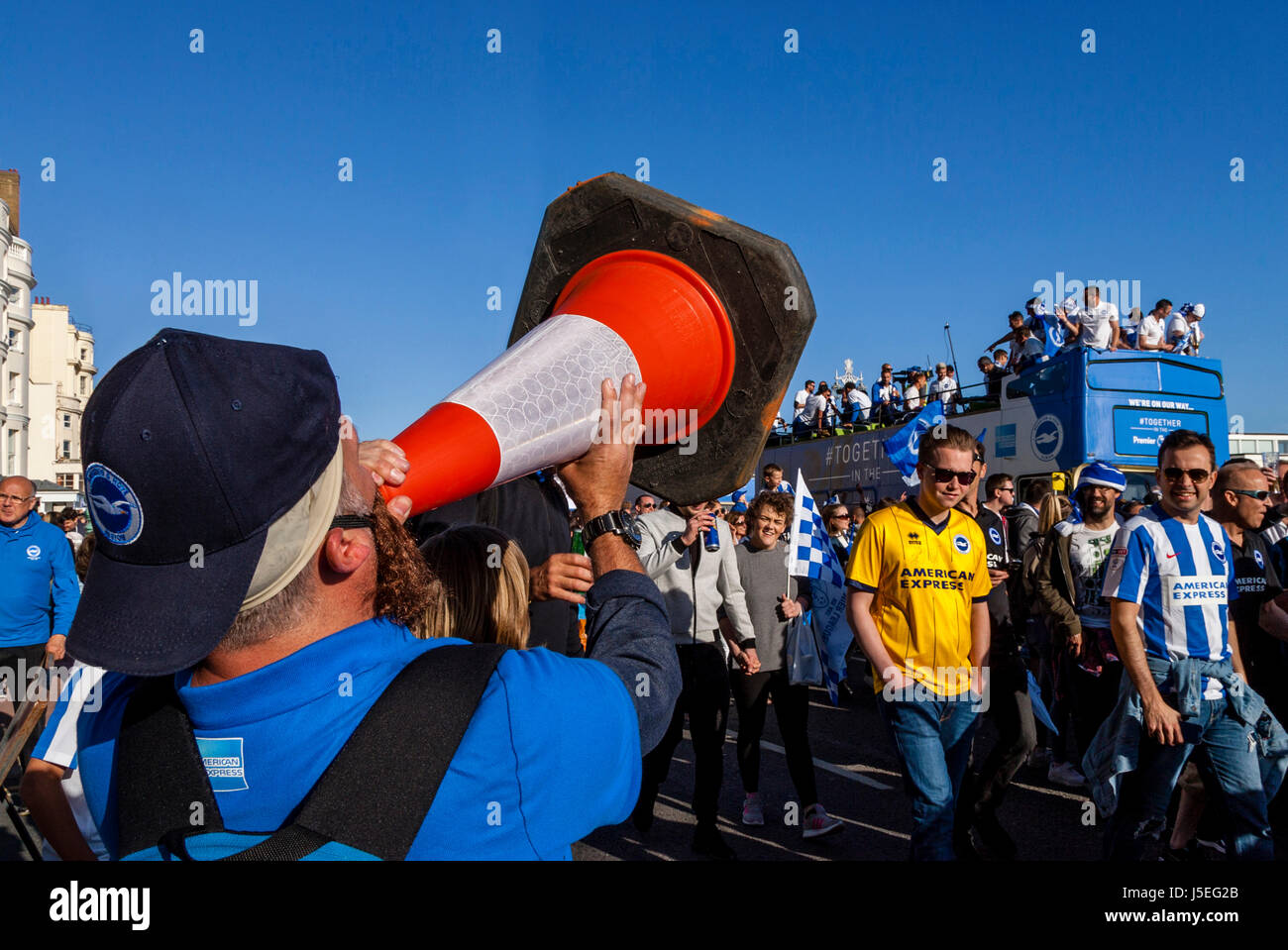 A Brighton and Hove Albion Football Fan Shouts Into A Traffic Cone As The The Team Bus Passes During The Club's Promotion Parade, Brighton, UK Stock Photo