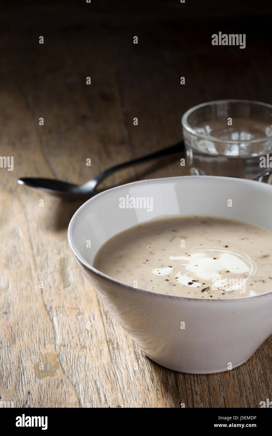 Cream of mushroom soup on a wooden table. Rustic and wholesome food. Stock Photo