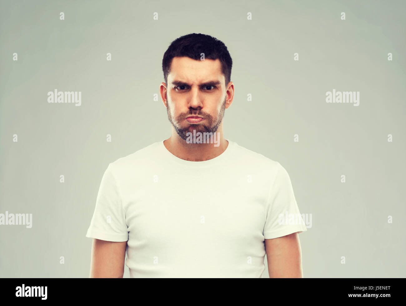 man with funny angry face over gray background Stock Photo