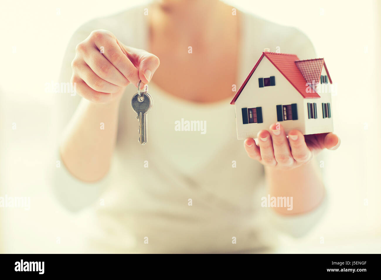 close up of hands holding house model and keys Stock Photo - Alamy