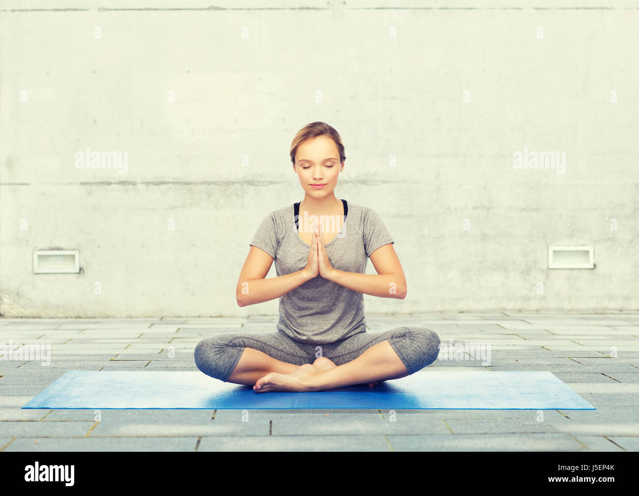 woman making yoga meditation in lotus pose on mat Stock Photo - Alamy