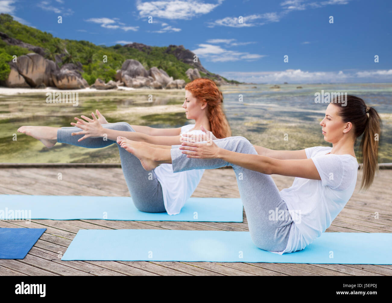 women making yoga in half-boat pose outdoors Stock Photo