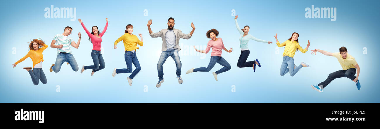 happy people or friends jumping in air over blue Stock Photo - Alamy