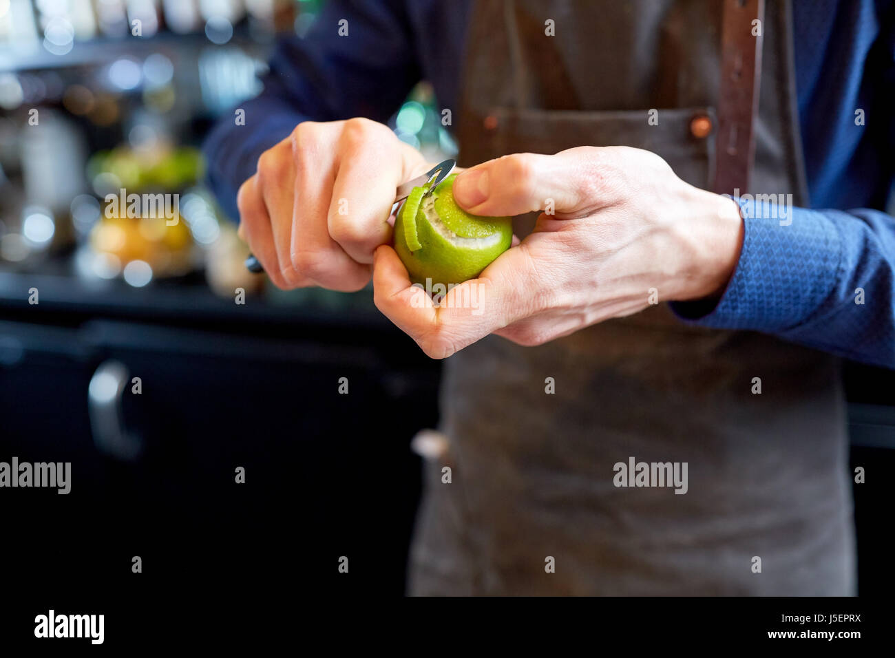 bartender removing peel from lime at bar Stock Photo Alamy