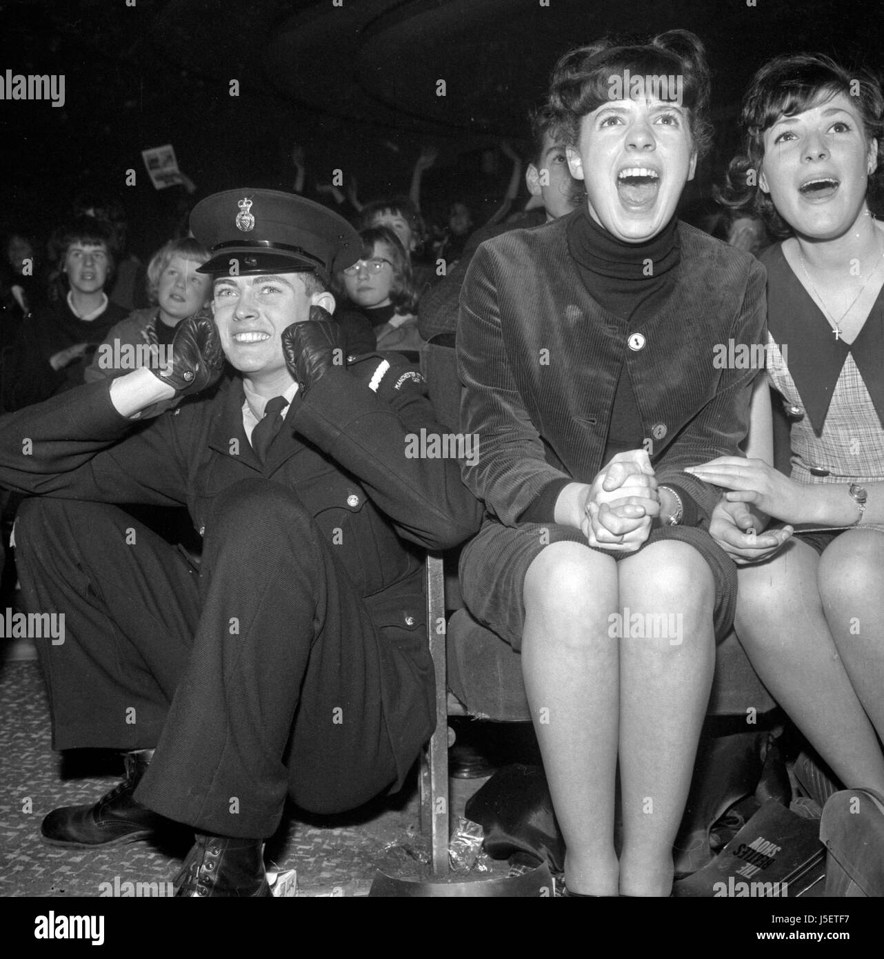 Screaming fans forces a policeman to take evasive action during the Beatles performance in Manchester. Stock Photo