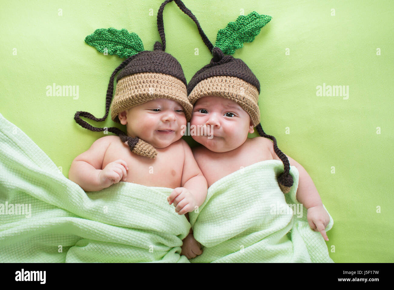 Twins brothers babies weared in acorn hats Stock Photo