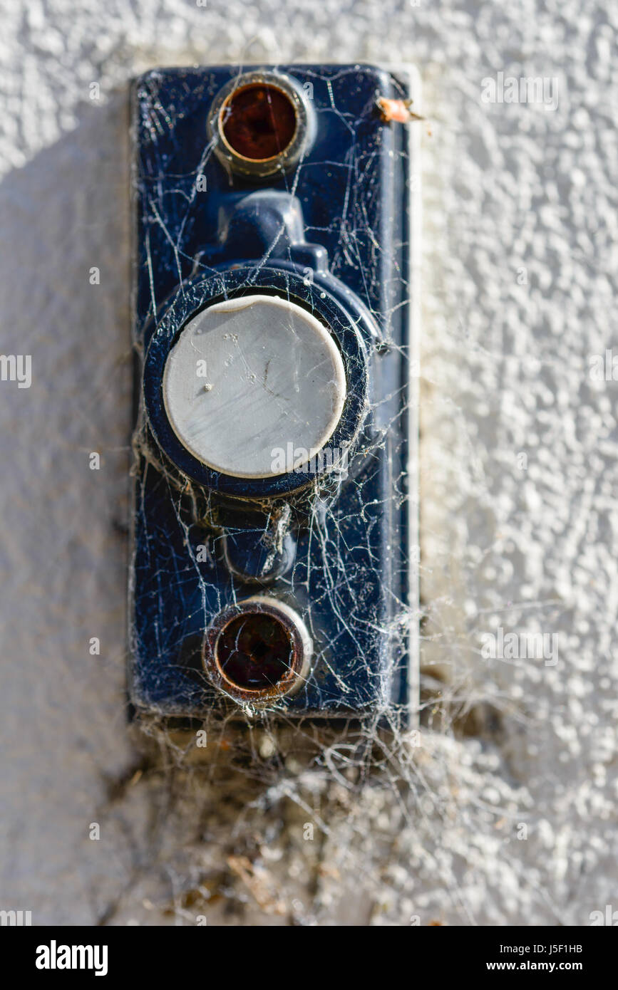 Faded doorbell covered with spider webs. Stock Photo