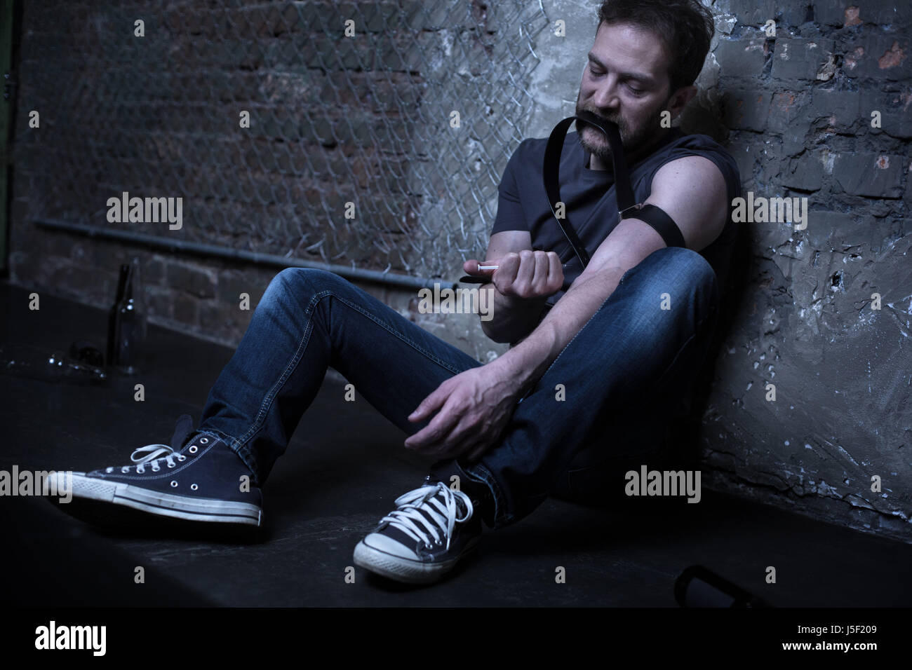 Desperate drug addict making heroin injection in the darkness Stock ...