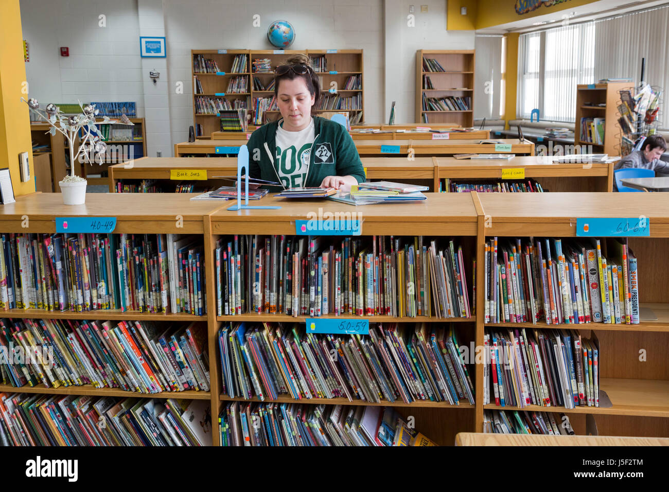Detroit, Michigan - Volunteers from Muslim, Jewish, and other groups clean, paint, and organize books in the library at Schulze Academy for Technology Stock Photo