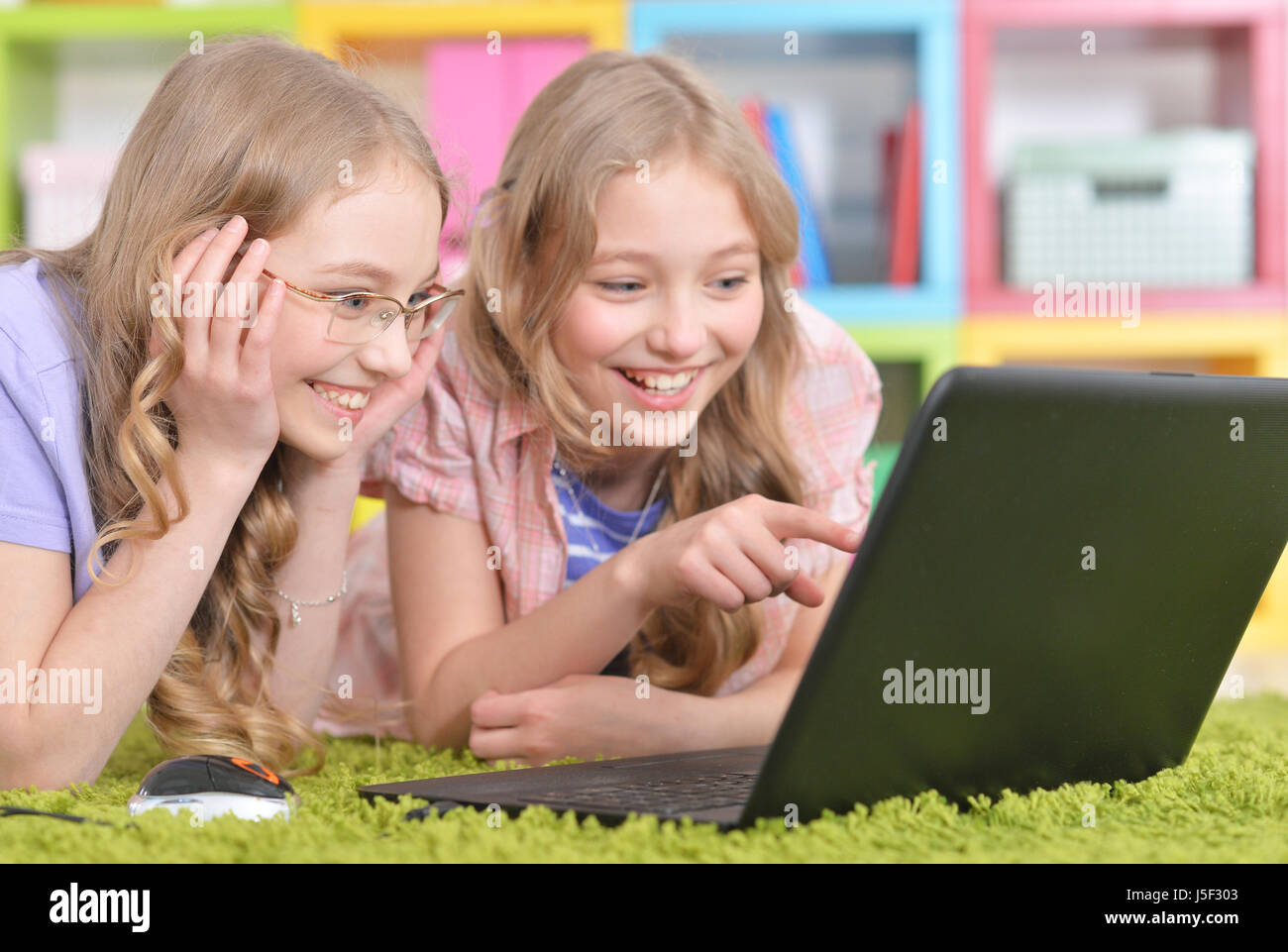 Teenagers sisters using laptop Stock Photo - Alamy