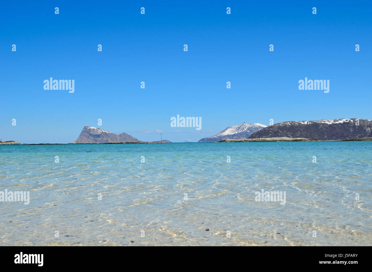 majestic white springtime beach with snowy mountain islands in sea on ...