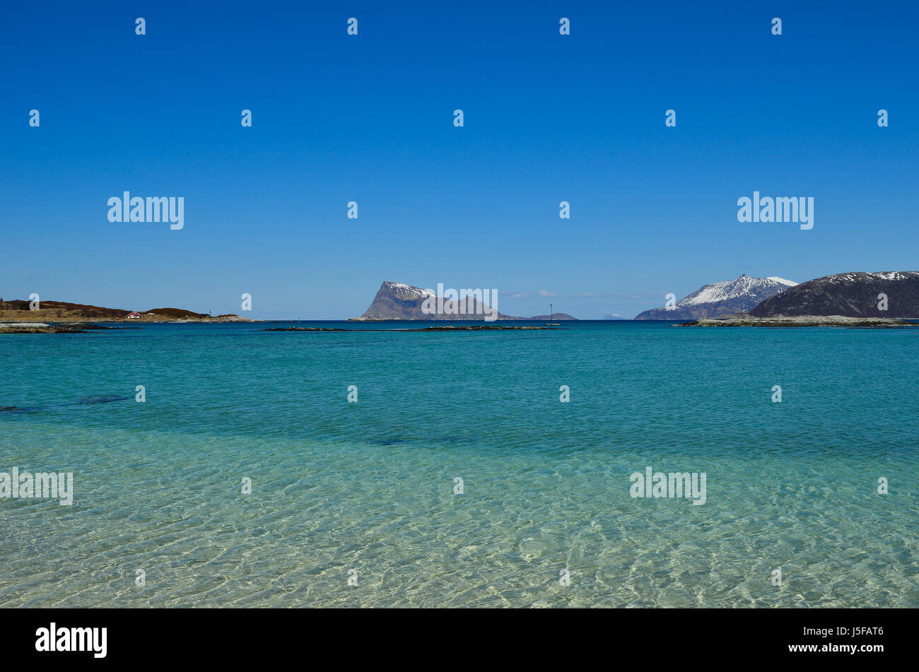 majestic white springtime beach with snowy mountain islands in sea on ...
