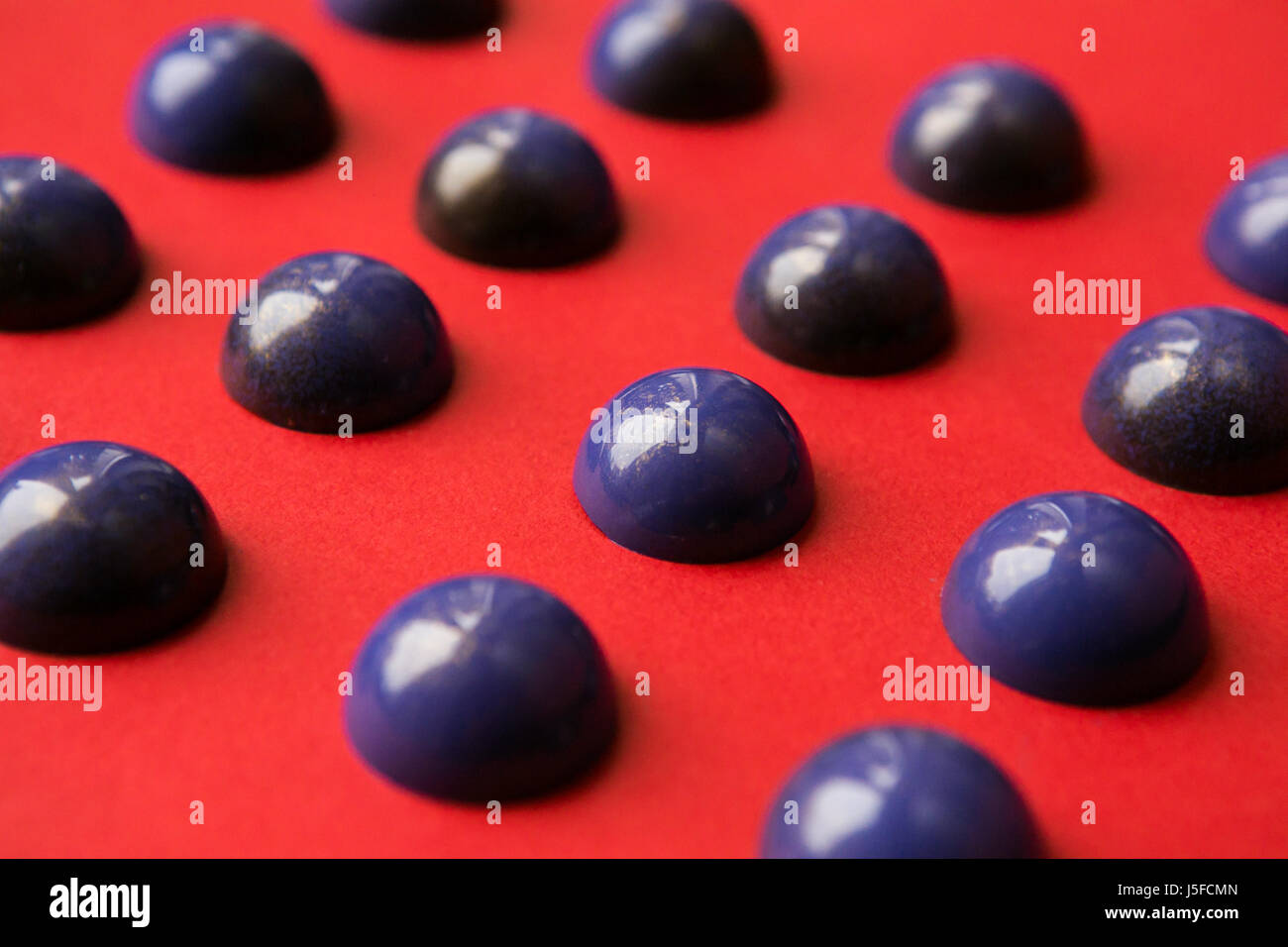 Handmade chocolate hemisphere on a red background. blank candy ...