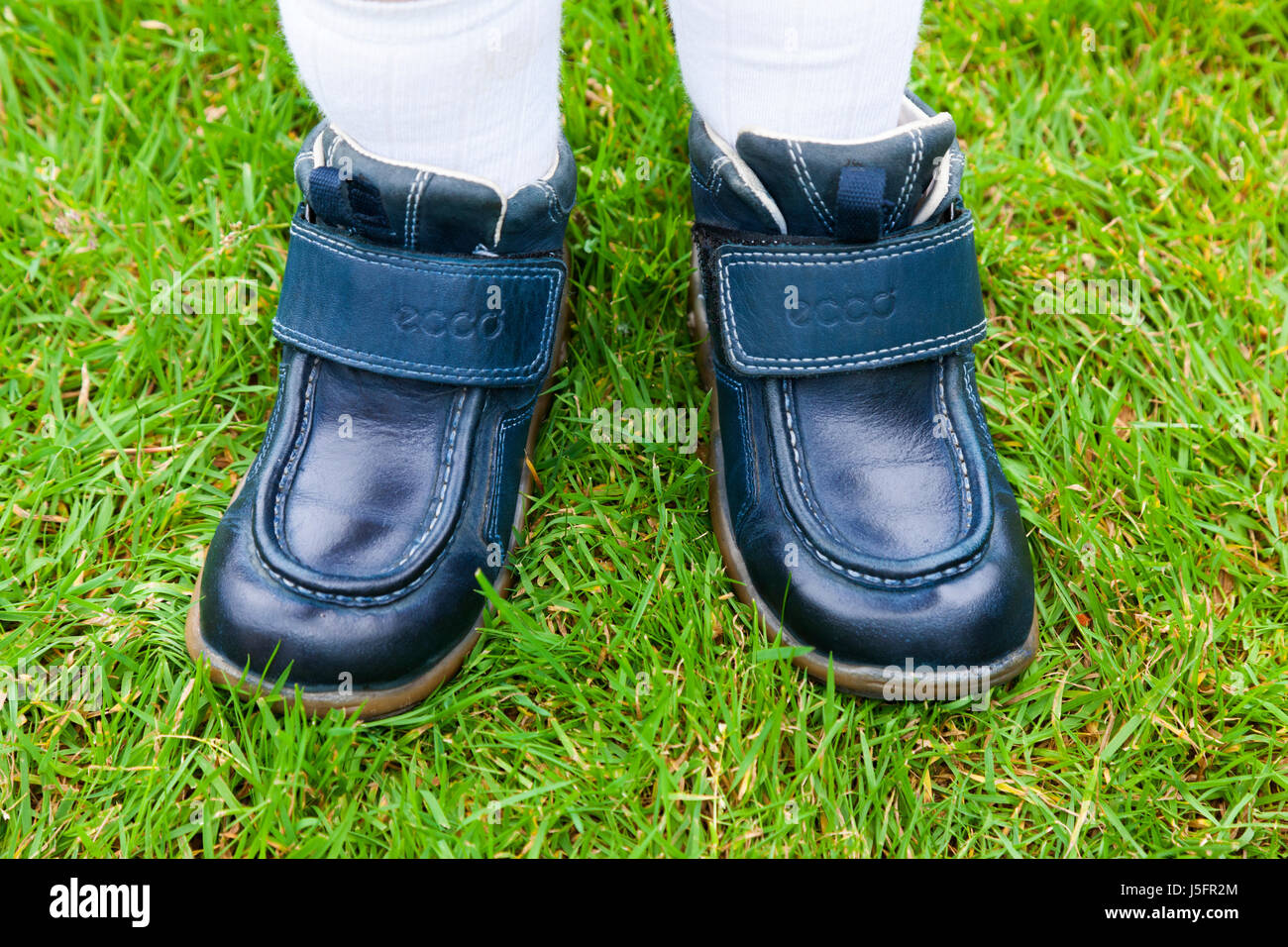 Childs / kid / young kids / children 's shoes on the wrong feet, so putting the right shoe on the left foot on the left you on the right foot. (87) Stock Photo