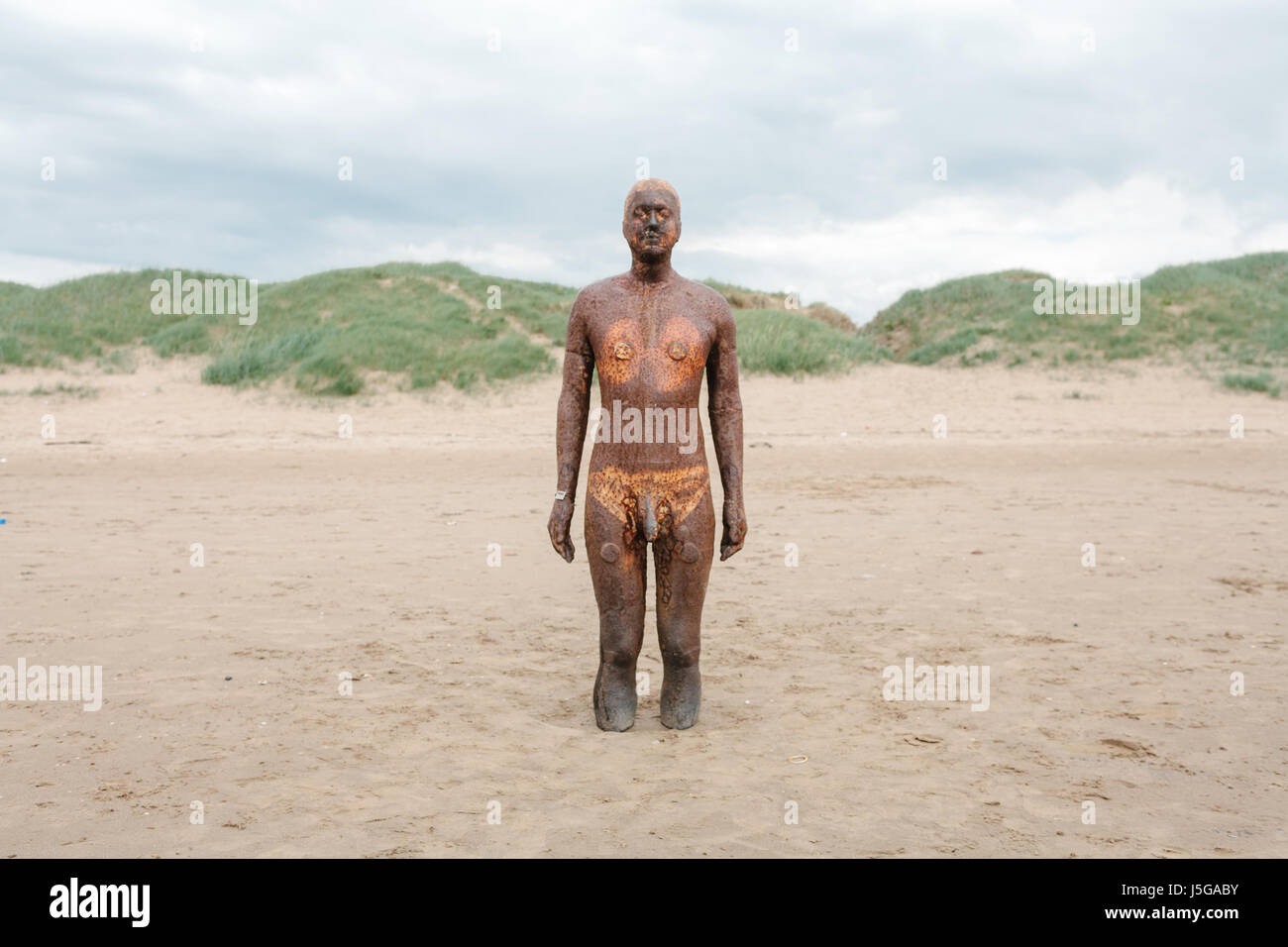 One of the statues in the Another Place installation by Antony Gormley on Crosby Beach, Liverpool, England Stock Photo