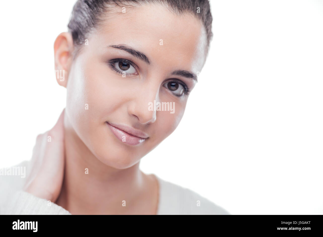 Attractive smiling woman touching her neck and posing on white ...