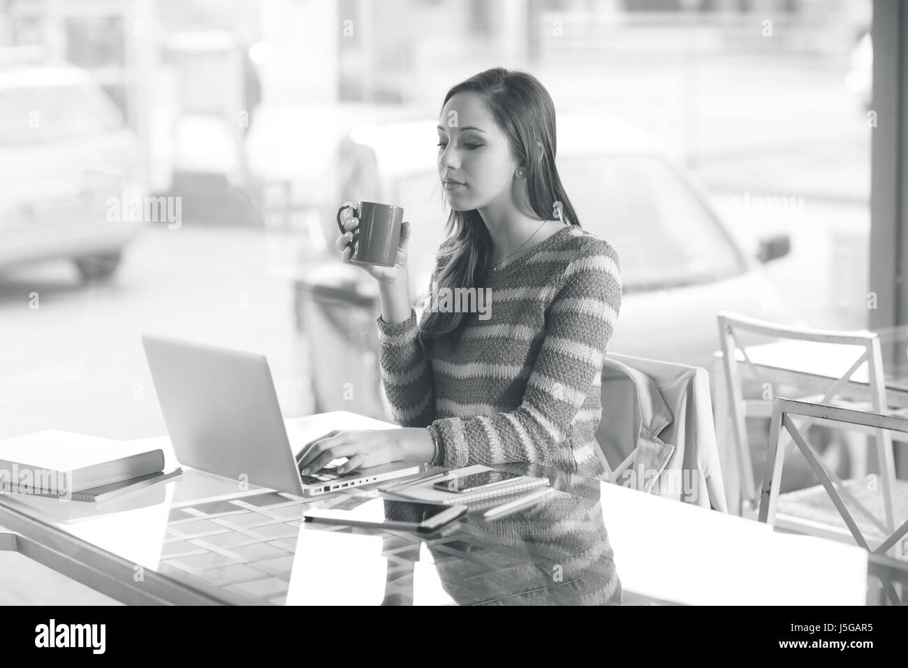 Busy young woman working with her laptop on a desk Stock Photo - Alamy
