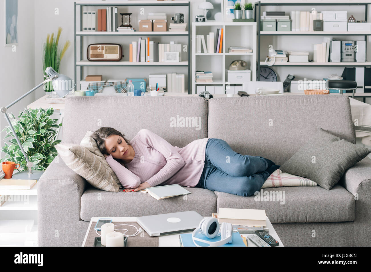 Beautiful young girl sleeping on the couch in the living room, she was reading a book Stock Photo - Alamy