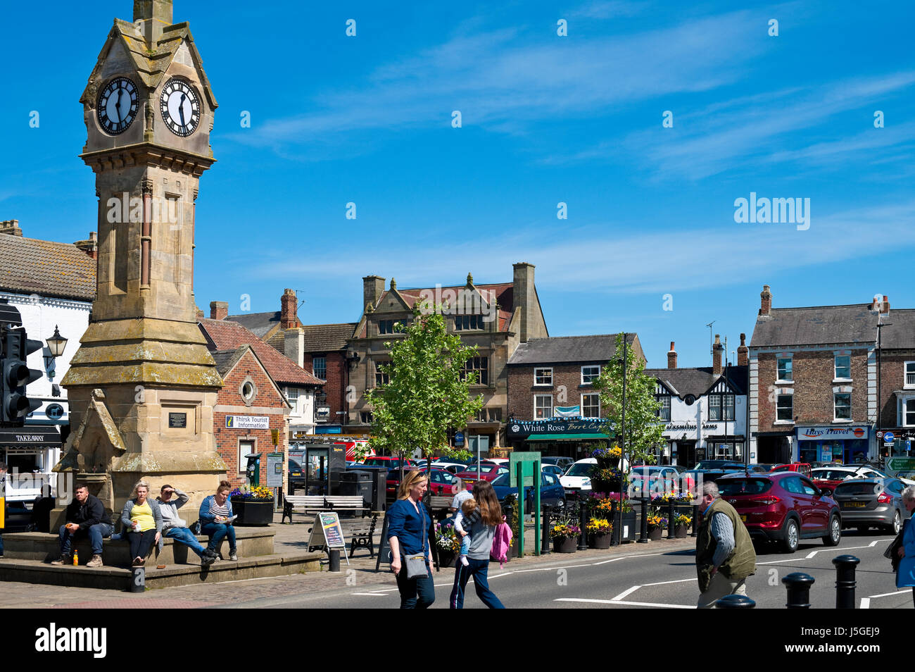 Market Place and Clock Tower people shopping shoppers in spring Thirsk town centre North Yorkshire England UK United Kingdom GB Great Britain Stock Photo