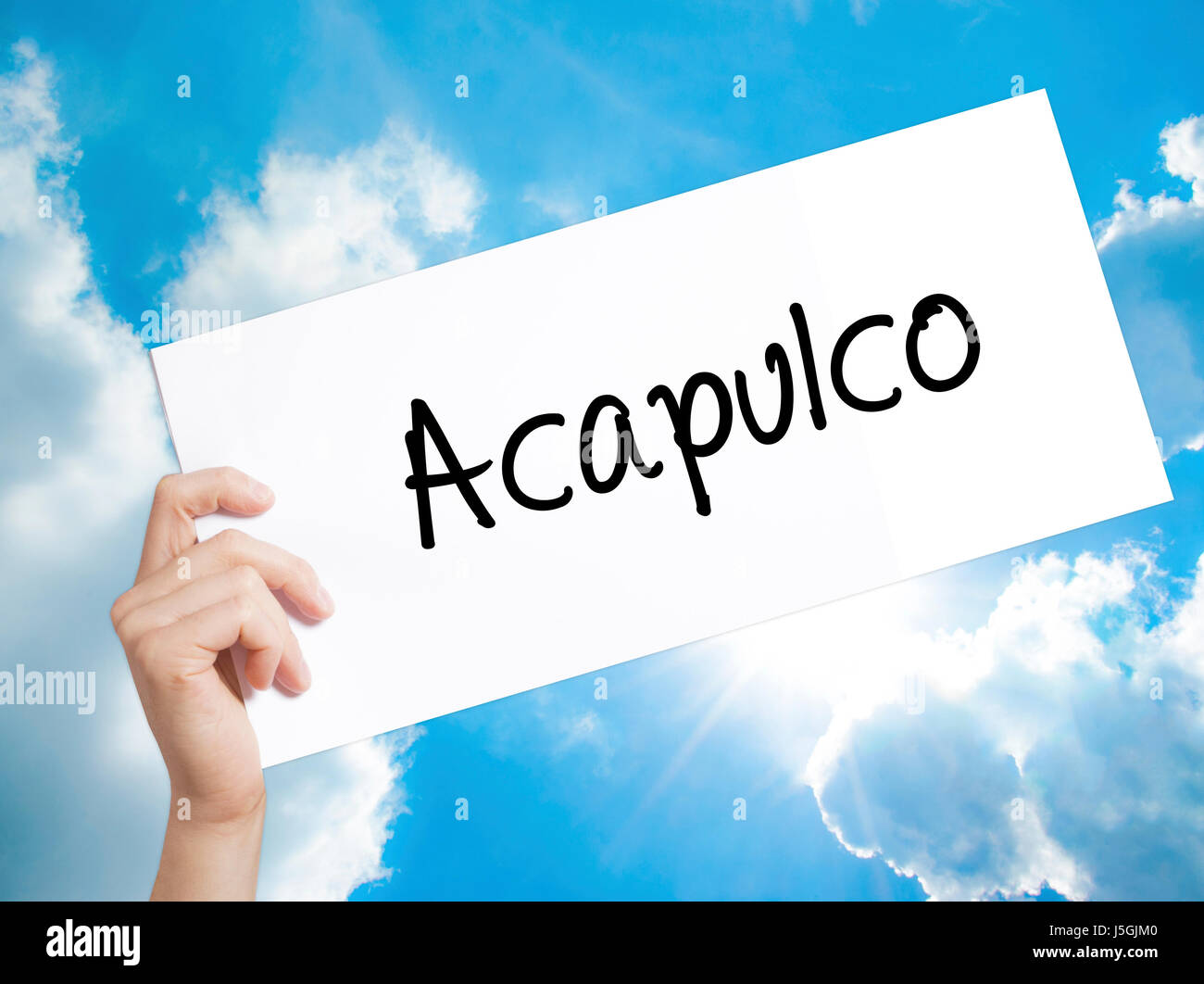 Acapulco  Sign on white paper. Man Hand Holding Paper with text. Isolated on sky background.  Business concept. Stock Photo Stock Photo