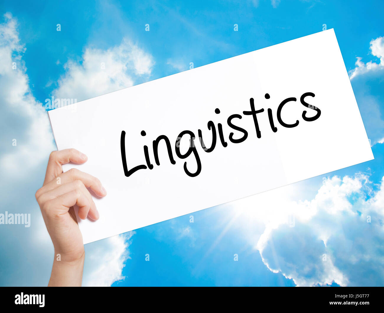 Linguistics  Sign on white paper. Man Hand Holding Paper with text. Isolated on sky background. Isolated on background. Business,   Business concept.  Stock Photo