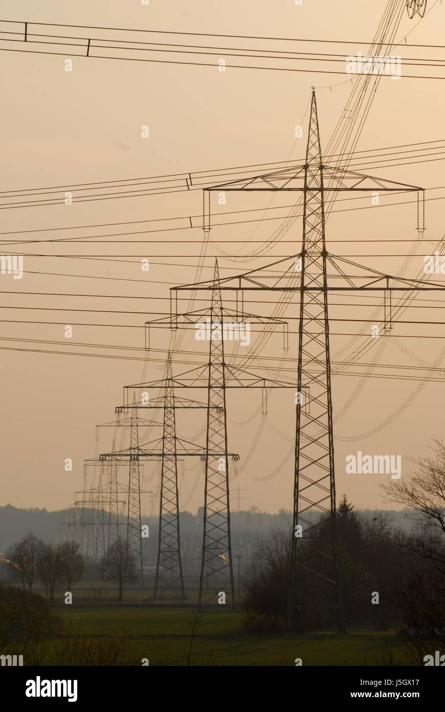 electricity pylons against evening sky Stock Photo