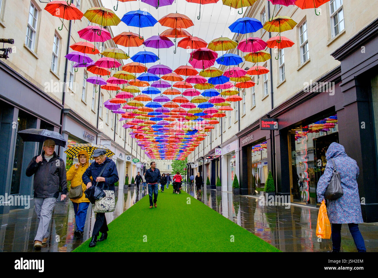 Bath, UK. 17th May, 2017. Shoppers braving the heavy rain in Bath are pictured as they walk