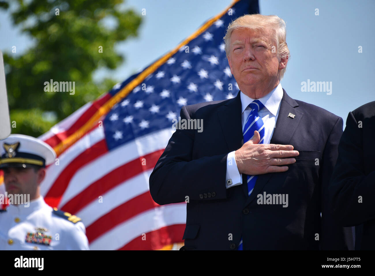 New London, USA. 17th May, 2017. U.S. President Donald Trump salutes during the national anthem at the 136th Coast Guard Academy commencement ceremony May 17, 2017 in New London, Connecticut. Credit: Planetpix/Alamy Live News Stock Photo
