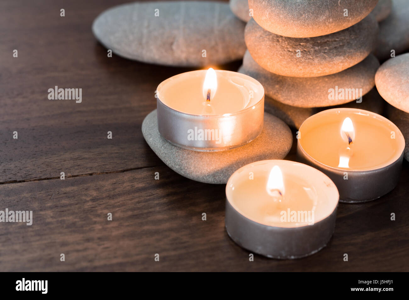 burning candles and pebble stones Stock Photo