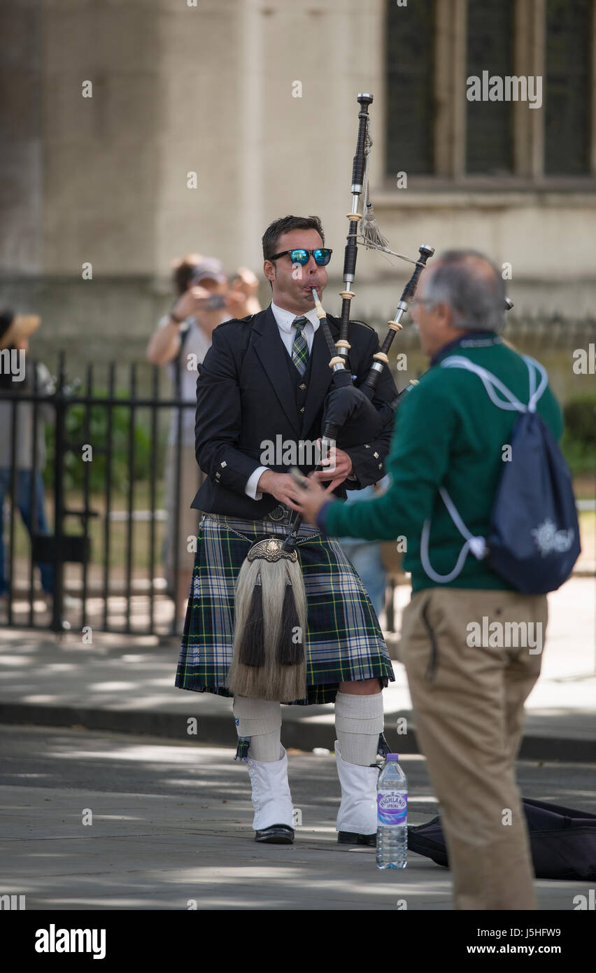 Man in highland dress playing bagpipes in Parliament Square, London UK Stock Photo