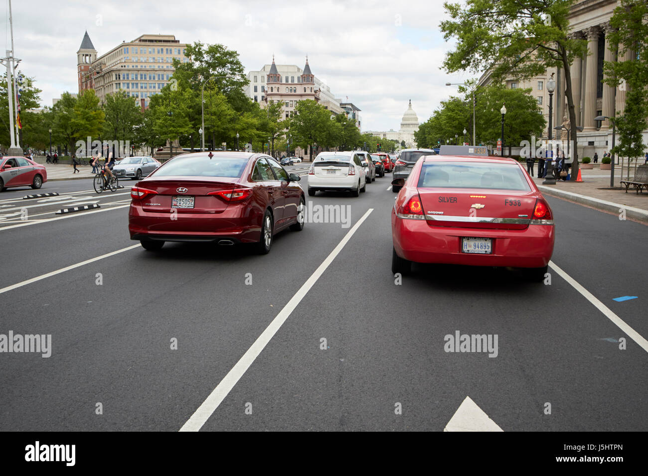 Washington DC red and grey stripe cab and other cars in traffic heading towards us capitol building on pennsylvania ave USA Stock Photo