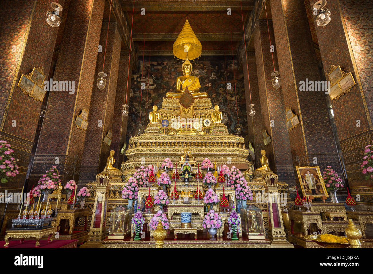 Ornate and golden altar inside the Phra Ubosot or Ordination Hall, which is the holiest prayer room at the Wat Pho (Po) temple complex in Bangkok. Stock Photo