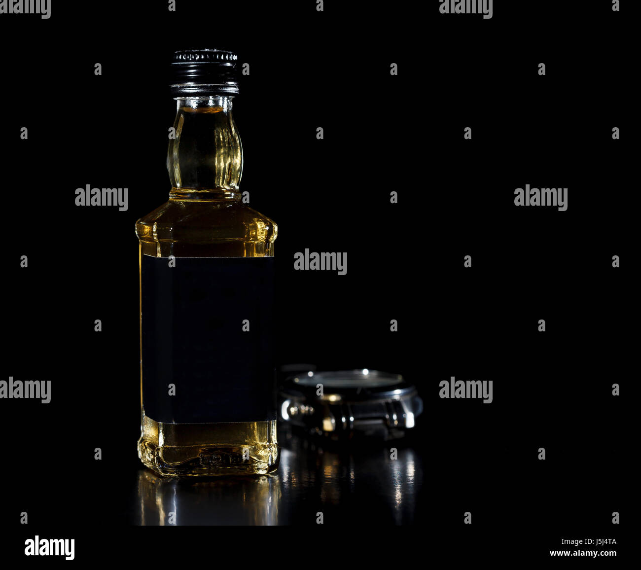 Glass bottle of whiskey on black background Stock Photo