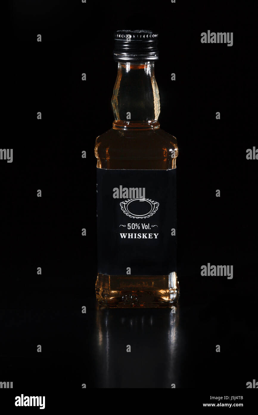 Glass bottle of whiskey on black background Stock Photo