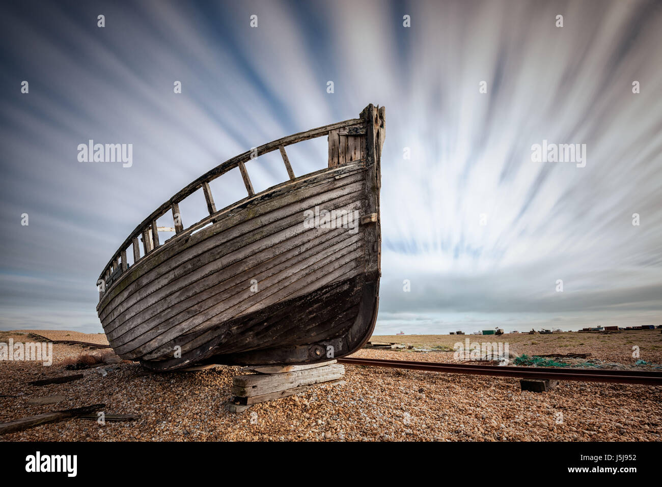 Singke abandoned old fishing boat on a pebble beach with long exposure ...