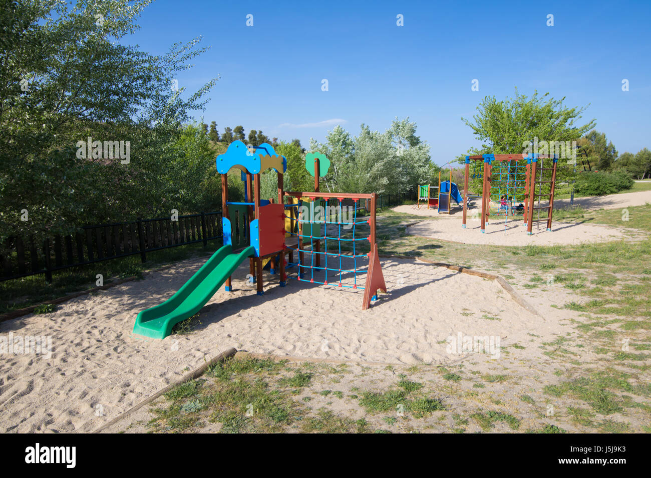 Plastic Two Swing Sets On Earth Sand Ground In Playground