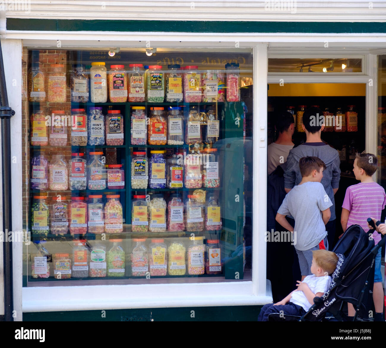 Kids queuing up to get in a sweet shop, England, UK Stock Photo