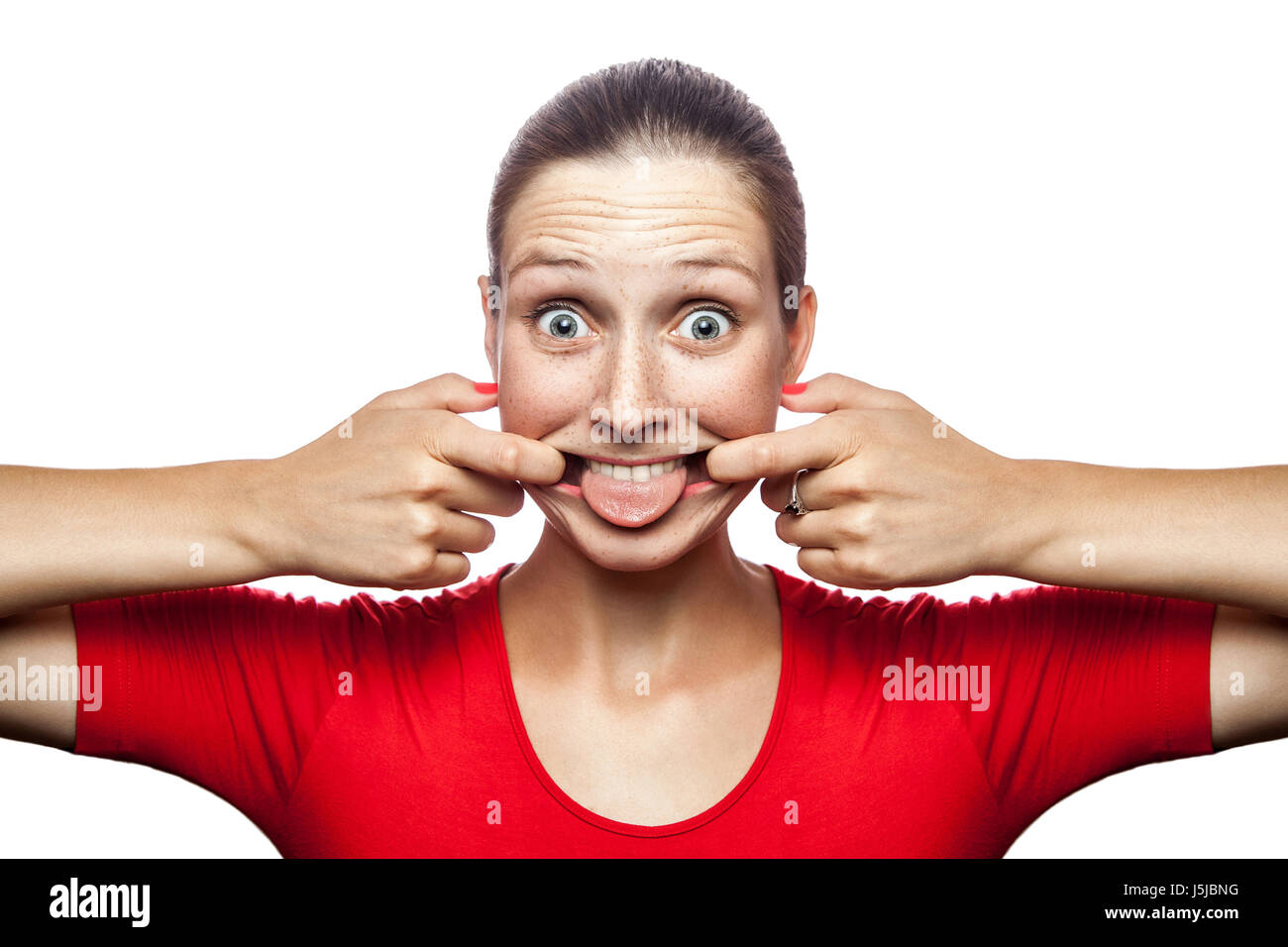 Portrait of crazy funny woman in red t-shirt with freckles. looking at camera, studio shot. isolated on white background. Stock Photo