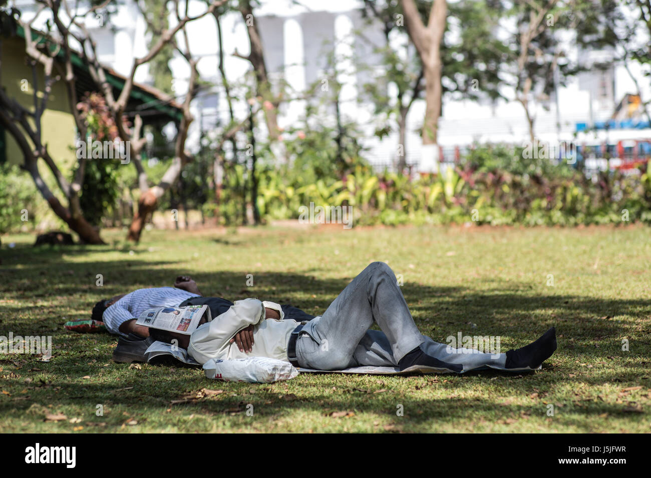 A man taking a nap in a park in Mumbai, India. Stock Photo