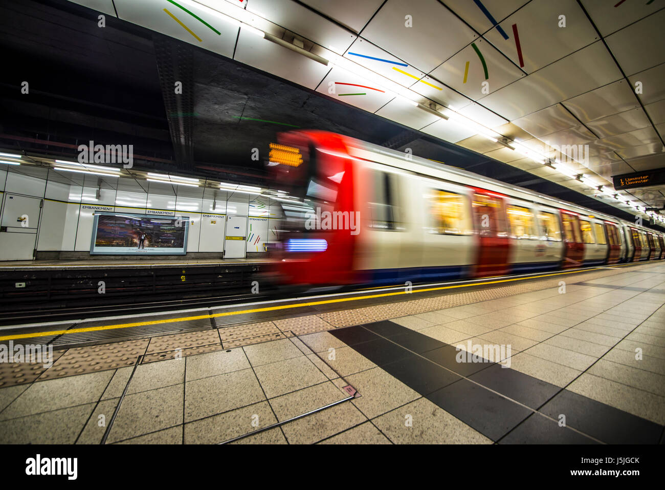Embankment London Underground Station with a train moving through Stock Photo