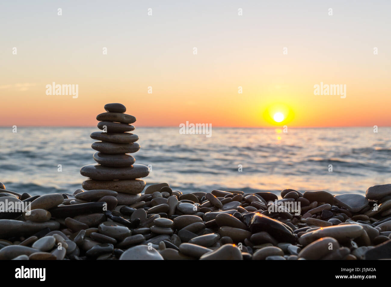 Stacked stones on the stony beach on sunset Stock Photo - Alamy