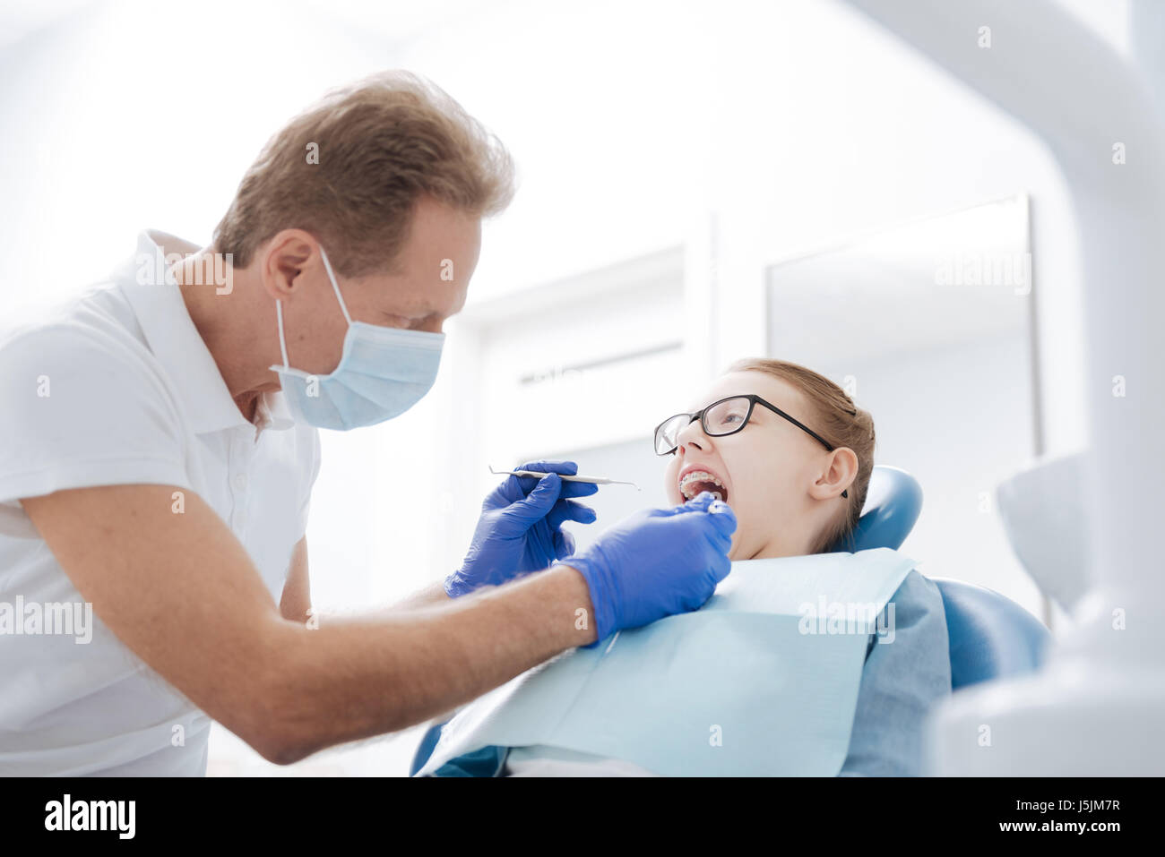 Clever observant dentist conducting an examination Stock Photo Alamy