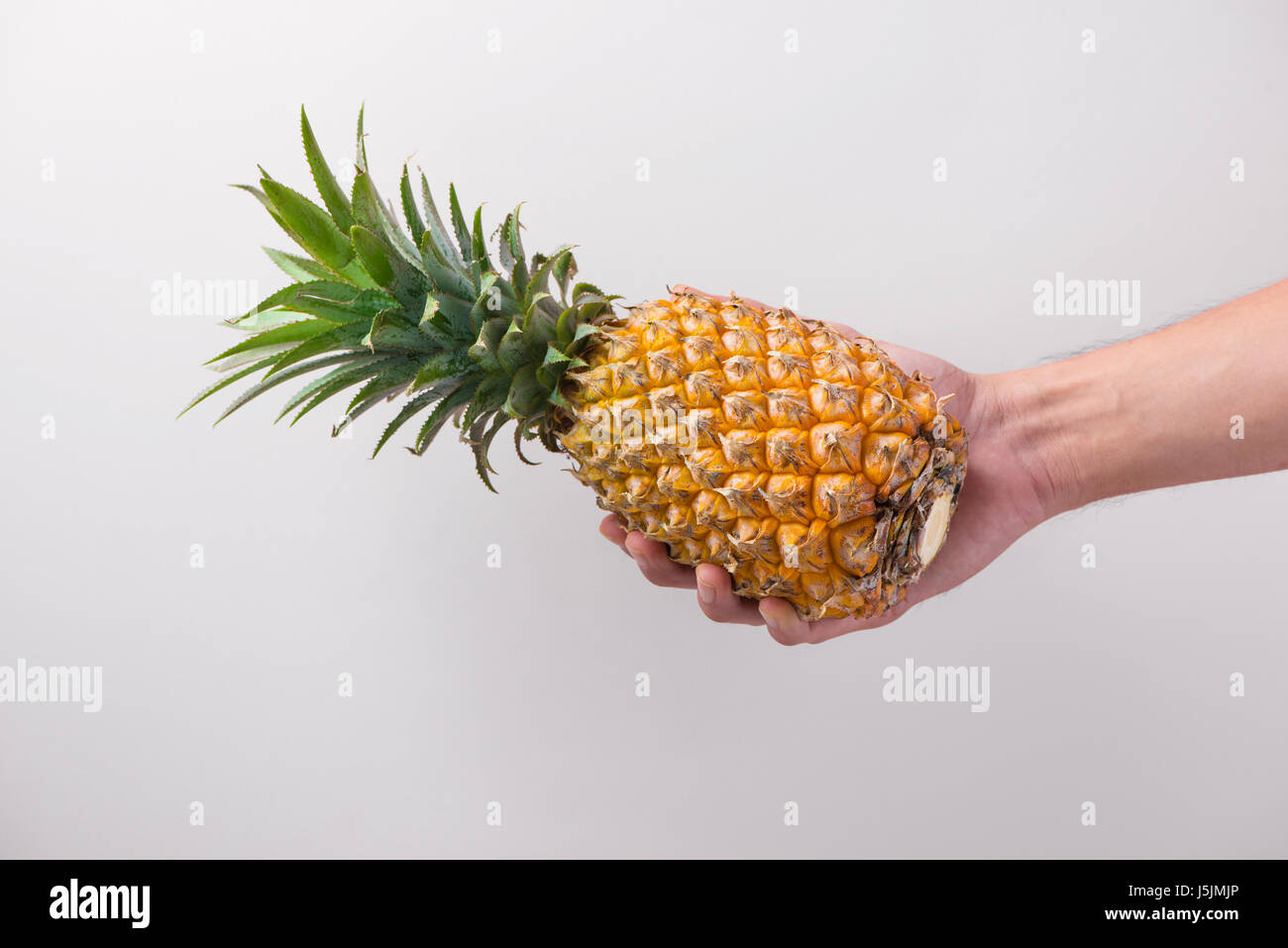 Male hand holding a pineapple isolated on white Stock Photo Alamy